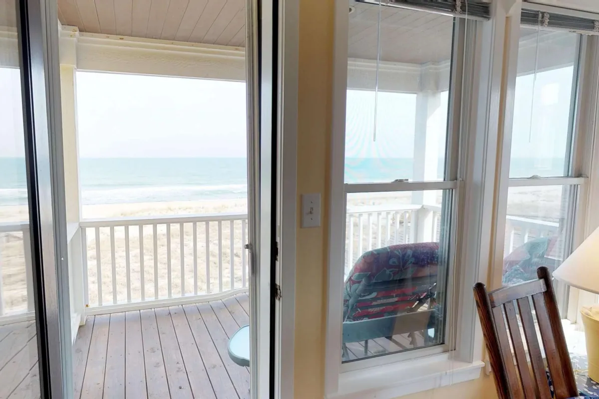A tranquil oceanfront deck with comfortable outdoor seating and sweeping views of the water. The scene evokes relaxation and social moments, such as enjoying morning coffee, hosting happy hour, or spending quiet time with loved ones while soaking up the coastal atmosphere.