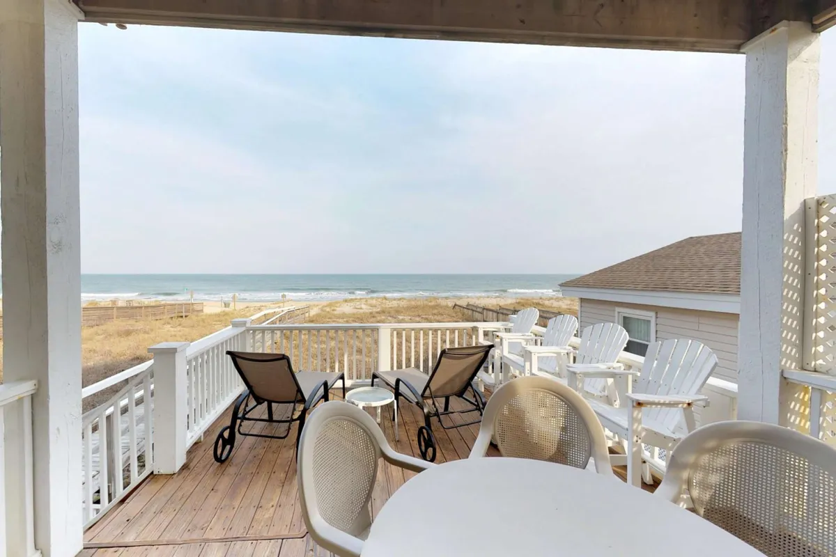 A serene outdoor deck scene featuring comfortable furniture and a table, all arranged to maximize enjoyment of the ocean view. The deck feels inviting for morning coffee, social gatherings, or stargazing with loved ones, and foregrounds the effortless transition from indoor comfort to coastal outdoors.